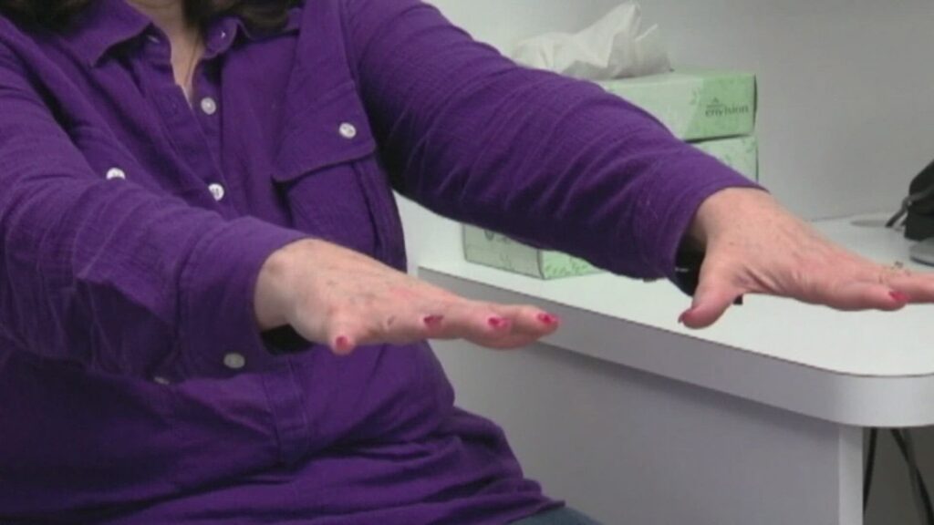 A patient sitting at a desk, reviewing medical bills while speaking on the phone