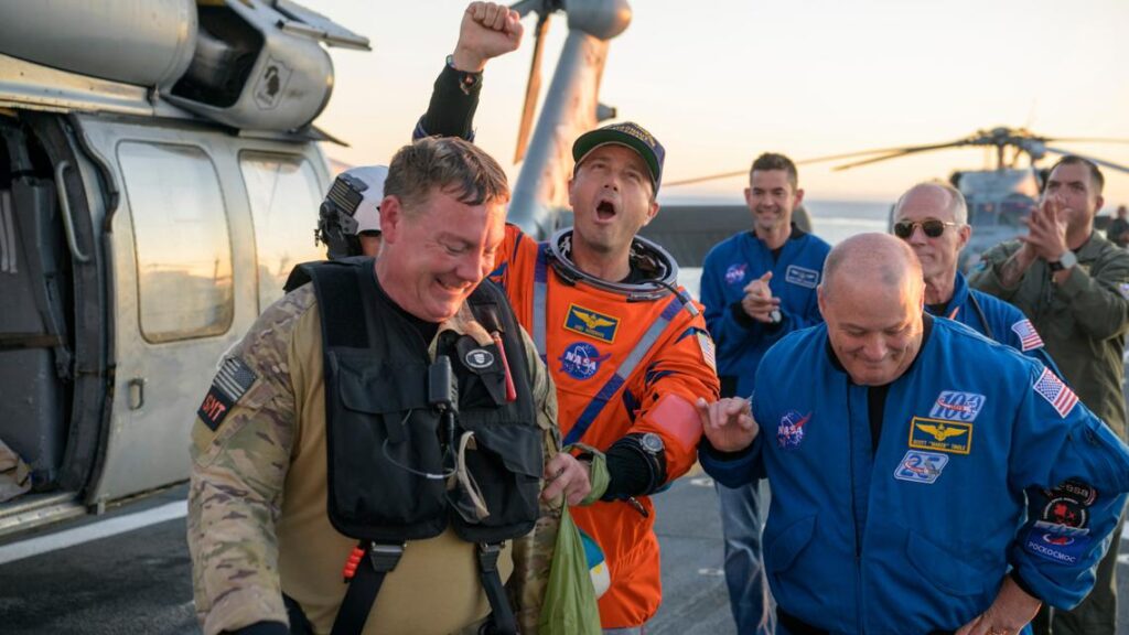 The Orion capsule glowing with intense heat as it hits Earth's atmosphere at Mach 33