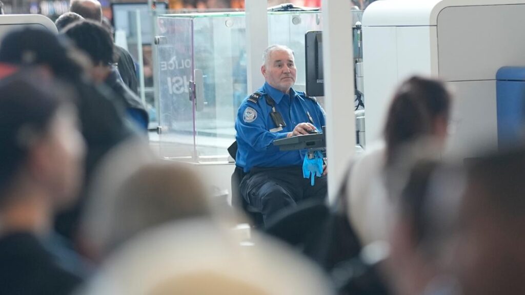 Travelers standing in long lines at a busy airport security checkpoint