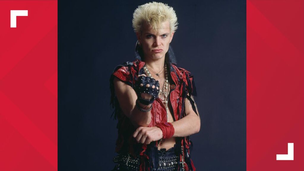 Phil Collins performing live on stage behind a drum kit and microphone